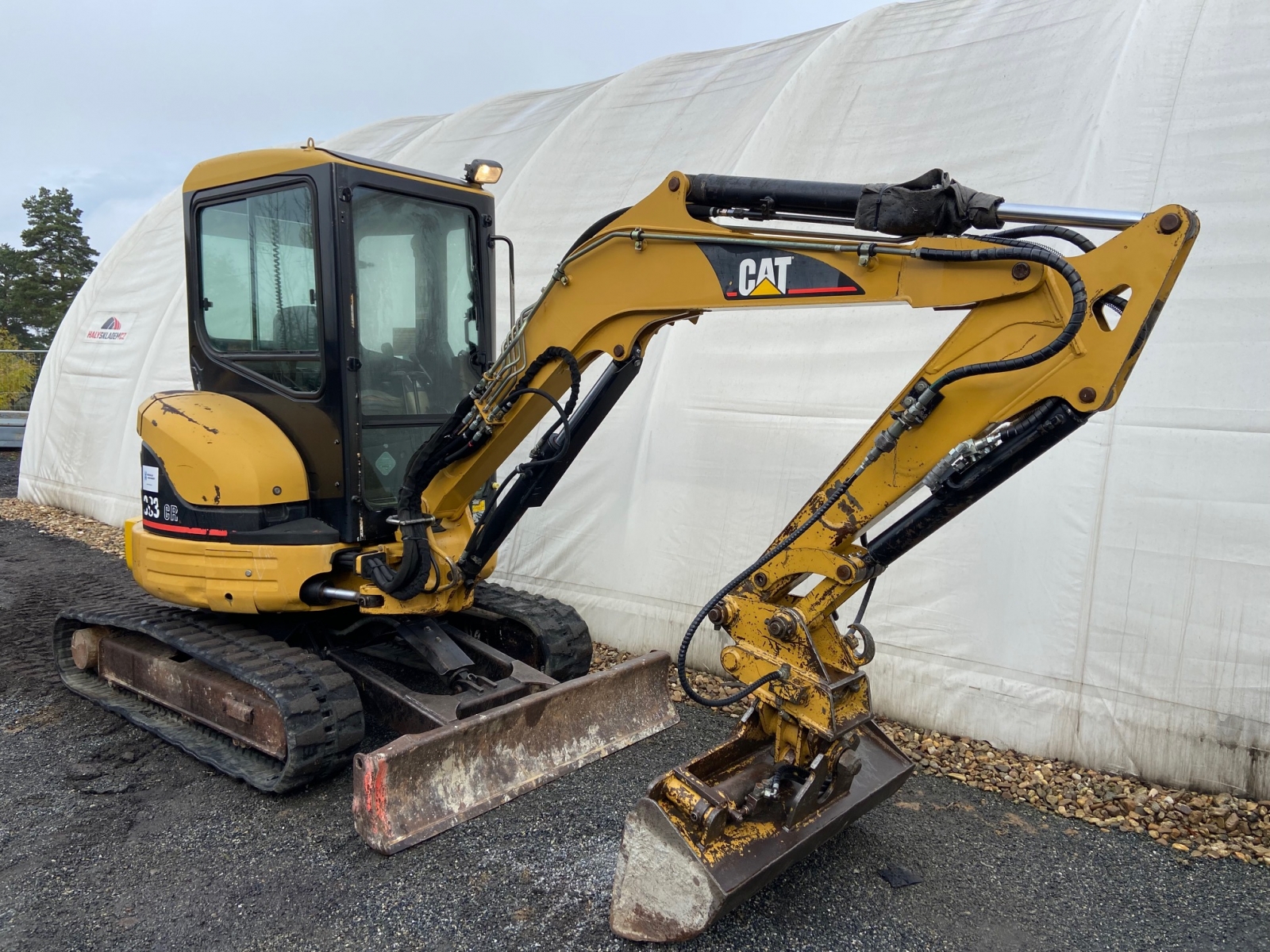 Pásové rypadlo CAT 303CR v terénu